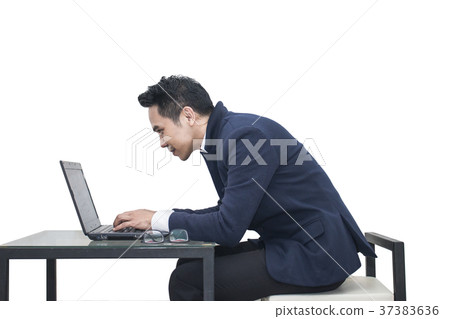 Businessman sitting at a desk using a laptop Businessman sitting at a desk using a laptop 37383636