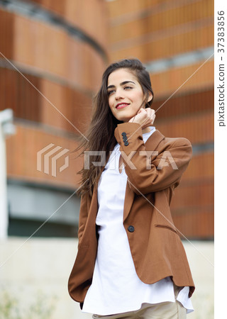 Young woman with nice hair standing outside of office building. Young woman with nice hair standing outside of office building. 37383856