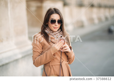 Stylish girl in a brown coat and a scarf with 37386612