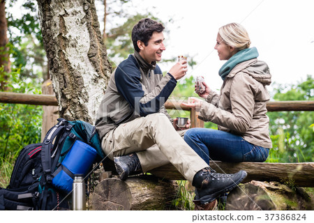Backpacker couple taking rest aside hiking trail 37386824
