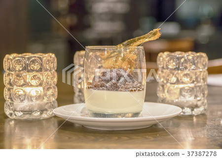 coffee in a glass in a glass plate whipped cream 37387278