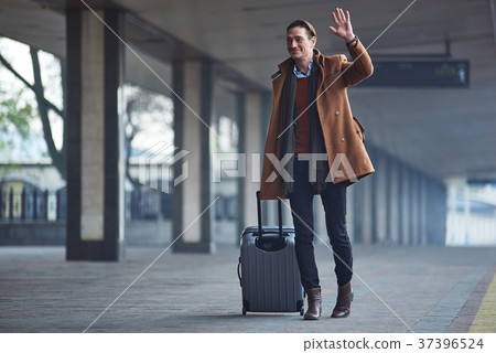 Cheerful man flourishing arm in street Cheerful man flourishing arm in street 37396524