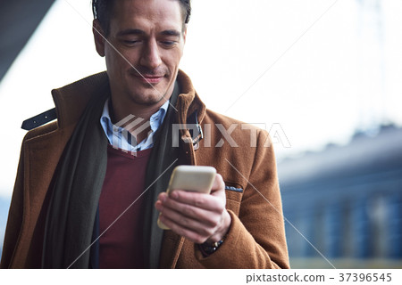 Cheerful man noting in phone Cheerful man noting in phone 37396545