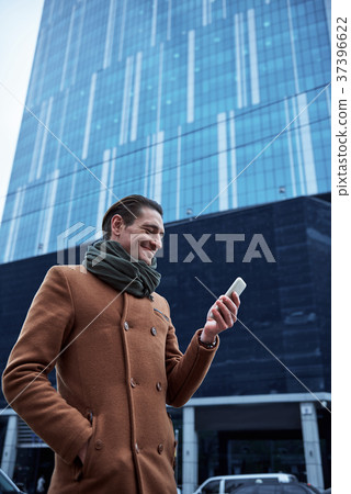 Cheerful male writing in mobile 37396622