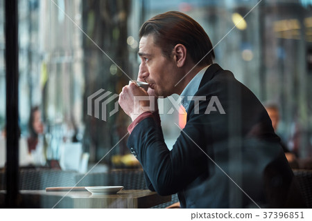 Serious male drinking mug of liquid Serious male drinking mug of liquid 37396851