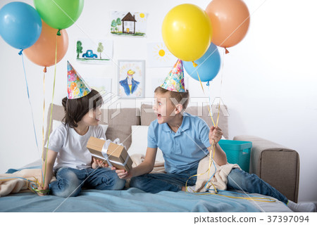 Pleased kids enjoying birthday party indoors Pleased kids enjoying birthday party indoors 37397094