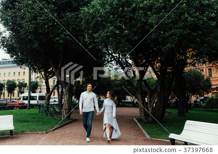 Romantic young couple walking hugging in street Romantic young couple walking hugging in street 37397668
