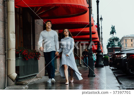 A loving couple hugs under the red store canopy on 37397701