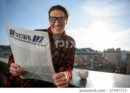 Happy adult male smiling and reading the journal 37397715