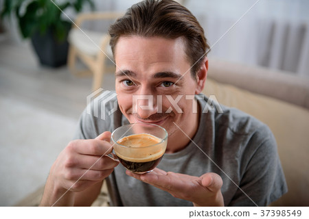 Contented man smelling tasty drink 37398549