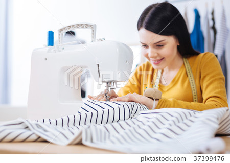 Experienced skilled tailor sitting at the sewing 37399476