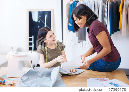 Smart coworkers looking excited while discussing a Smart coworkers looking excited while discussing a 37399678