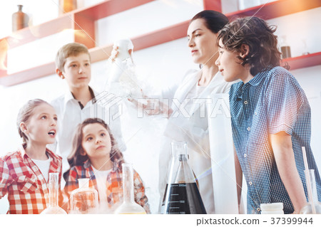 Female chemist showing fuming flask her little 37399944