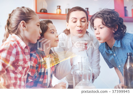 Children blowing on fuming laboratory flask at 37399945