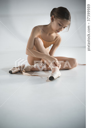 Beautiful little ballerina puting on foot pointe Beautiful little ballerina puting on foot pointe 37399989