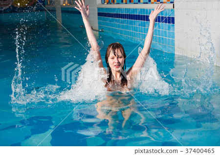 Girl in blue swimming pool with splash and drops 37400465