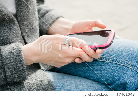 Beautiful young hipster woman using pink smart Beautiful young hipster woman using pink smart 37401048