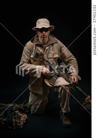 special forces soldier kneels with a rifle on a black background special forces soldier kneels with a rifle on a black background 37402192
