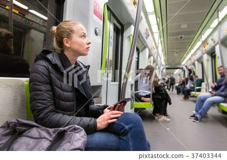 Young girl with mobile phone traveling on metro. 37403344