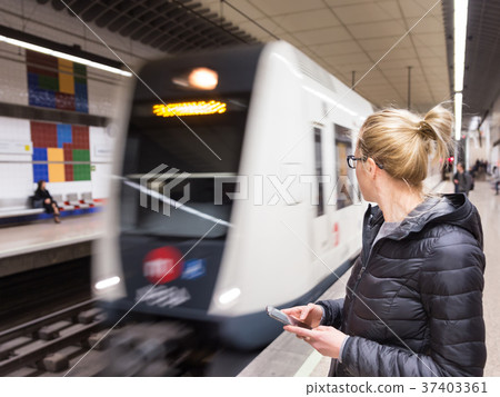 Woman with a cell phone waiting for metro. Woman with a cell phone waiting for metro. 37403361