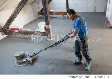 Laborer polishing sand and cement screed floor. 37403394