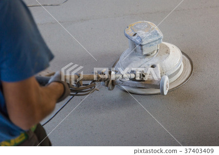 Laborer polishing sand and cement screed floor. 37403409