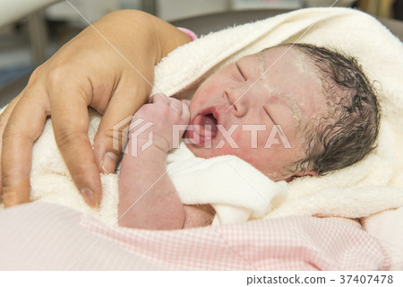 A newborn baby held by a mother A newborn baby held by a mother 37407478