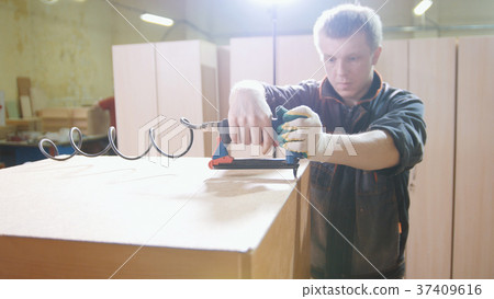 Carpenter working with an electric industrial Carpenter working with an electric industrial 37409616