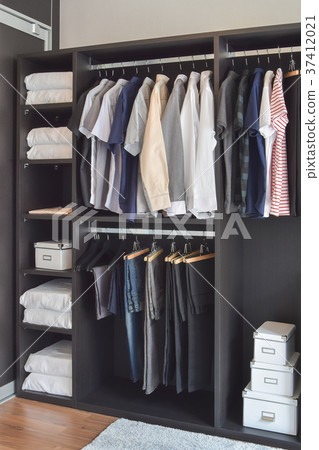 modern closet with cloths hanging in wardrobe modern closet with cloths hanging in wardrobe 37412021