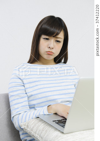 Young woman playing computer on the couch 37412220