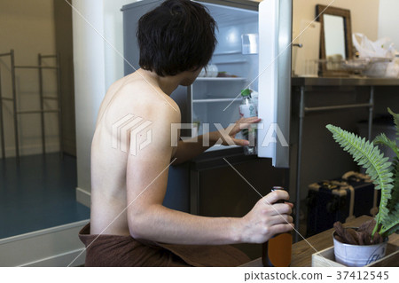 A man who opens a refrigerator 37412545