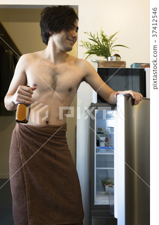 A man who opens a refrigerator 37412546