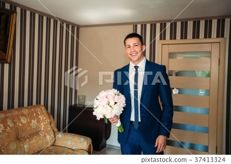 The groom is dressed at home in a suit. Cute groom The groom is dressed at home in a suit. Cute groom 37413324