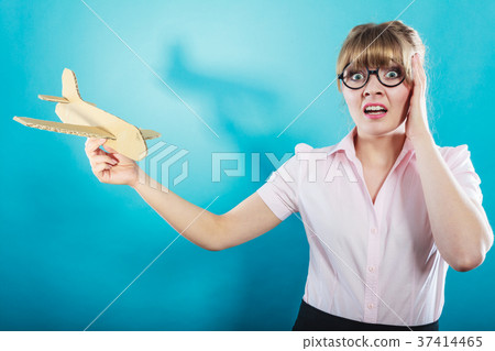 Fly fear. Woman holding airplane in hand. 37414465