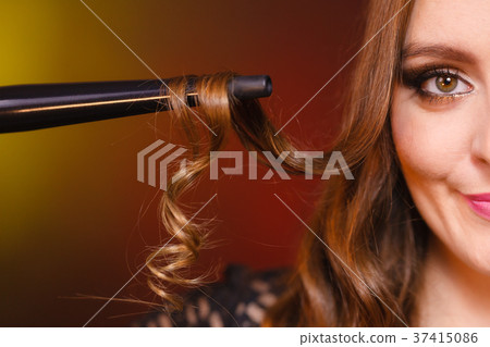 Happy woman curling her long brown hair 37415086