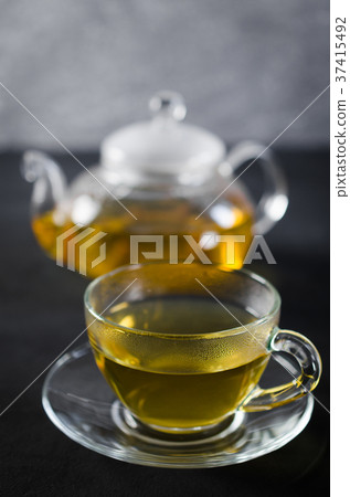 Cup of delicious herbal tea and glass teapot. Cup of delicious herbal tea and glass teapot. 37415492