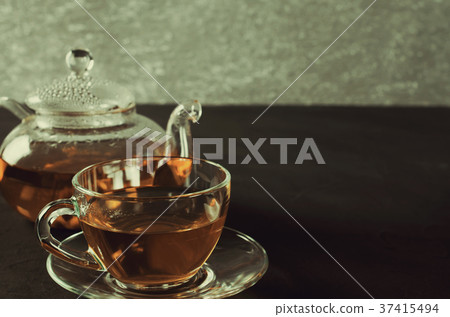 Cup of delicious herbal tea and glass teapot. Cup of delicious herbal tea and glass teapot. 37415494