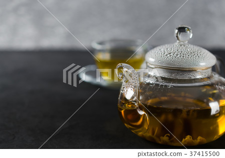 Cup of delicious herbal tea and glass teapot. Cup of delicious herbal tea and glass teapot. 37415500