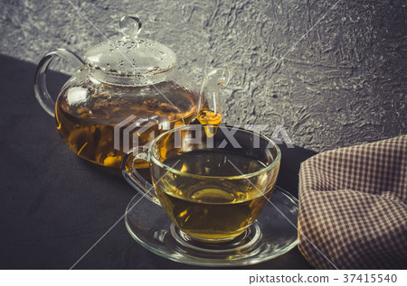 Cup of delicious herbal tea and glass teapot. 37415540