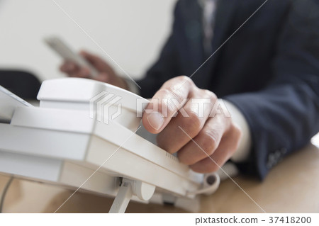 商人手回答的電話在辦公室,當操作智能手機時 商人手回答的電話在辦公室,當操作智能手機時 37418200