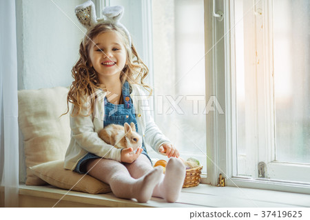 Cute happy little child girl is wearing bunny ears Cute happy little child girl is wearing bunny ears 37419625