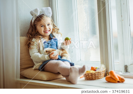 Cute happy little child girl is wearing bunny ears Cute happy little child girl is wearing bunny ears 37419631