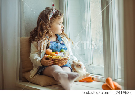 Beautiful happy child girl is sitting on window 37419682