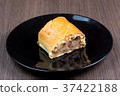 Slice of apple strudel on a black plate 37422188