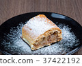 Slice of apple strudel on a black plate 37422192
