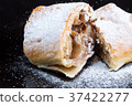 Two pieces of apple strudel on a black plate 37422277