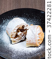 Two pieces of apple strudel on a black plate 37422281