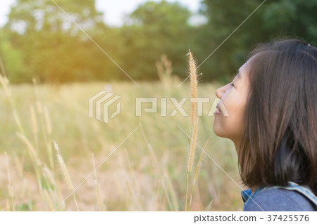 Asian girl playing in the grass field Asian girl playing in the grass field 37425576