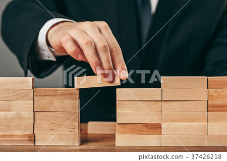 Man and wooden cubes on table. Management concept Man and wooden cubes on table. Management concept 37426218