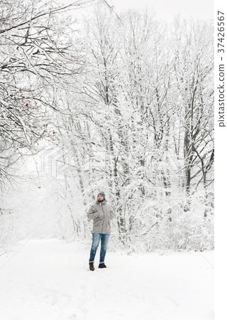 a man in a snowy forest view from afar 37426567